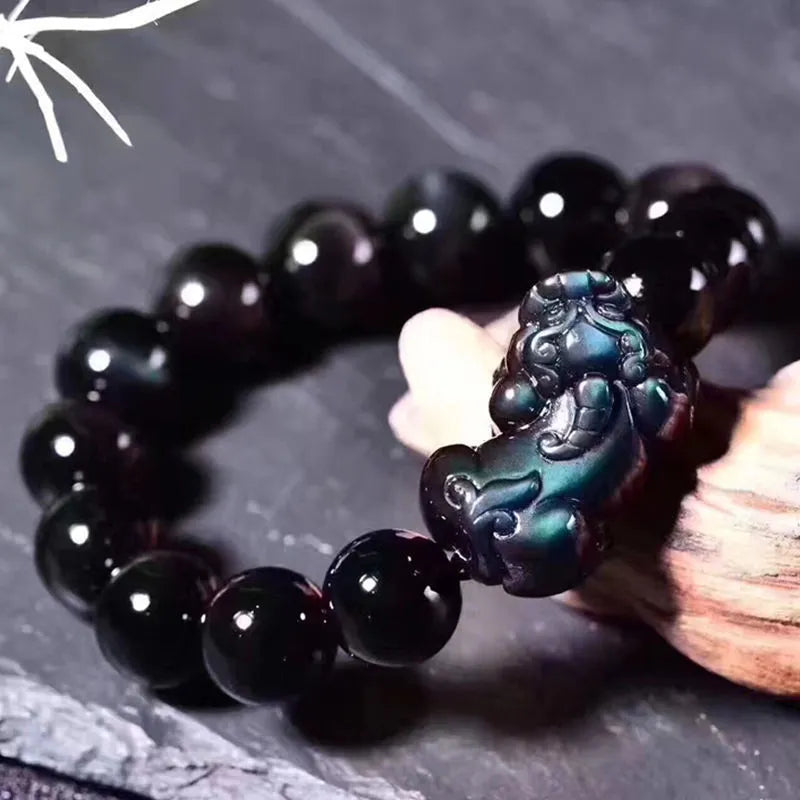 Natural ice colour eye obsidian crystal bracelet with spherical beads on a wrist.