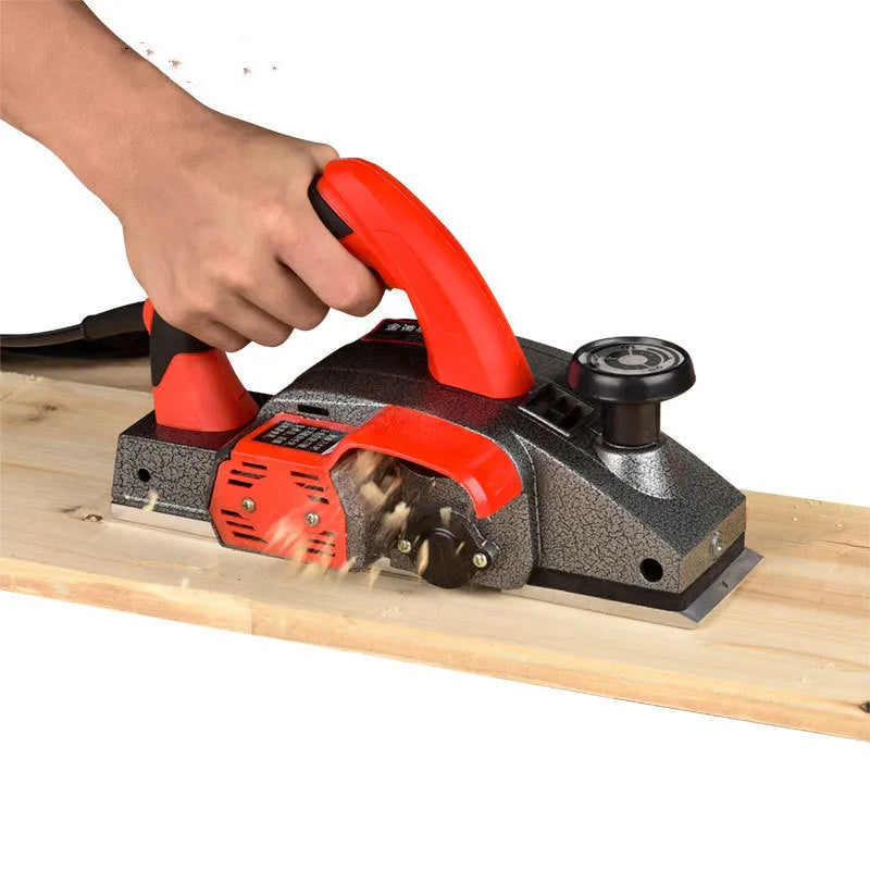 Red electric wood planer with aluminium body and 82mm planing width for household carpentry