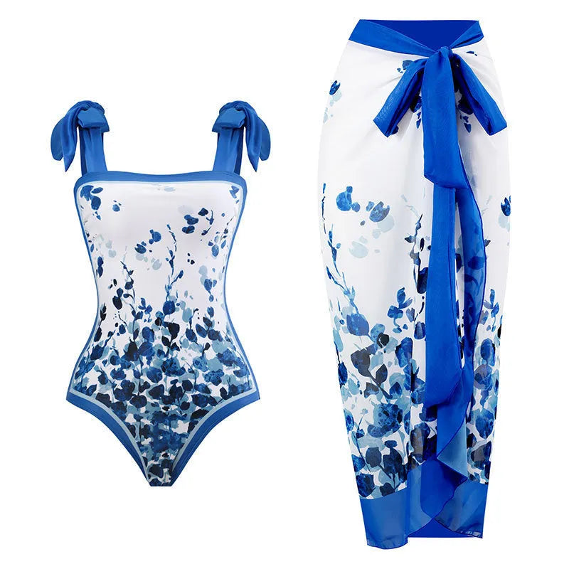 Women's yellow one-piece swimsuit with floral pattern and matching white chiffon skirt.
