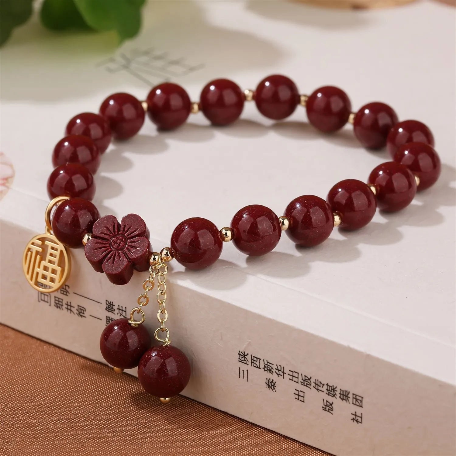 Women's cinnabar bracelet with fu character charm in purple gold sand colour and peach blossom detailing