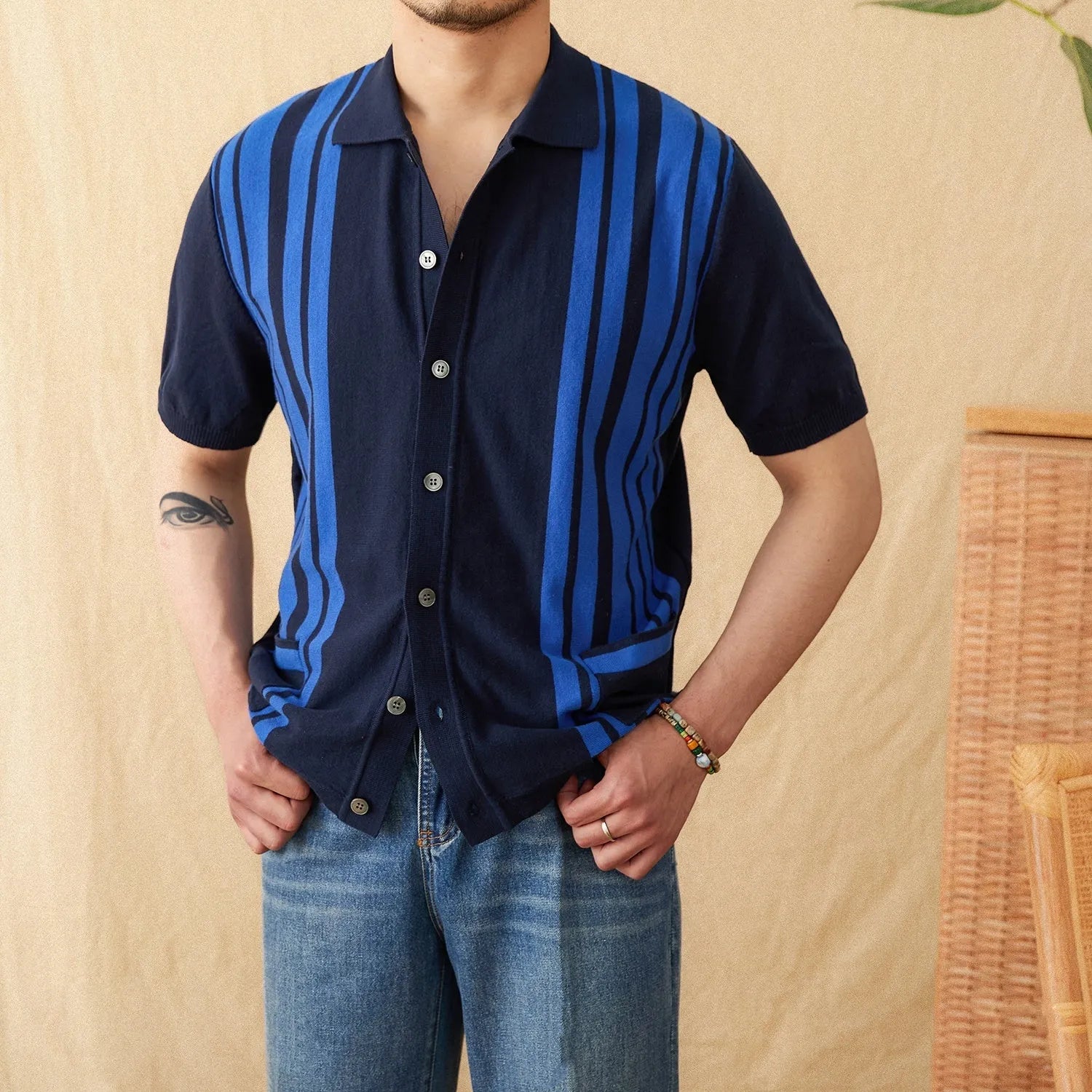 Royal blue striped short-sleeved knitted cardigan polo shirt with a lapel collar laid flat.