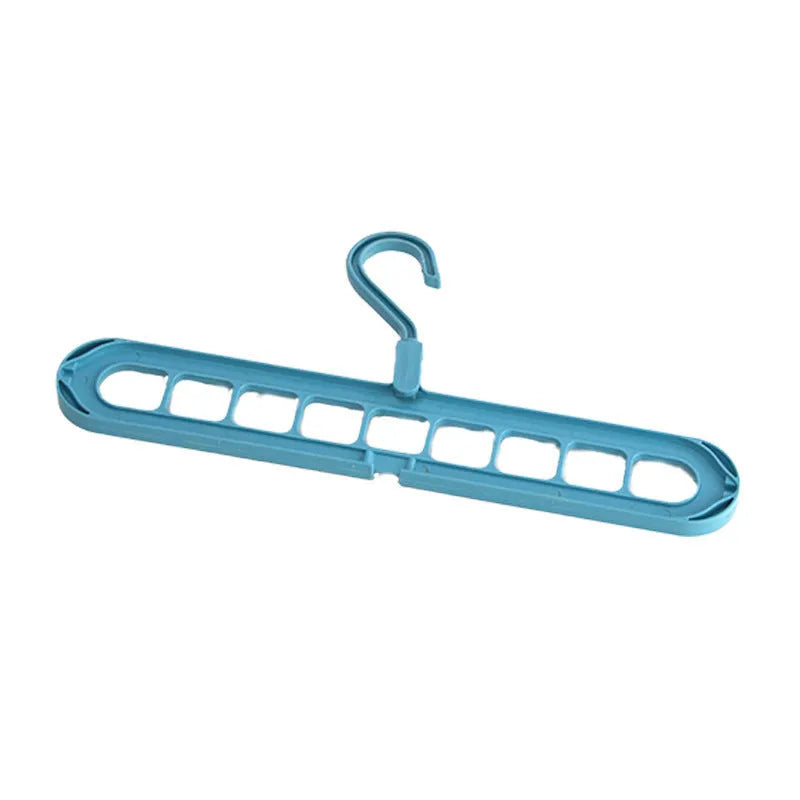 Green plastic nine-hole folding hanger for trousers shown in a dormitory wardrobe.