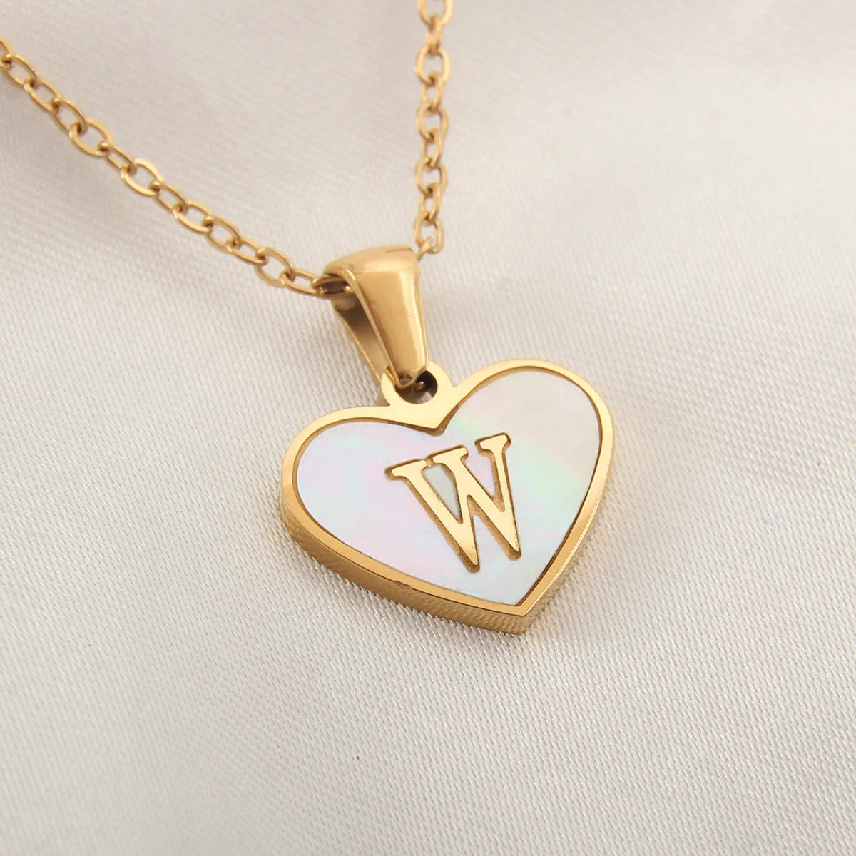 Gold heart necklace with white shell detail and personalised initial letter on adjustable chain