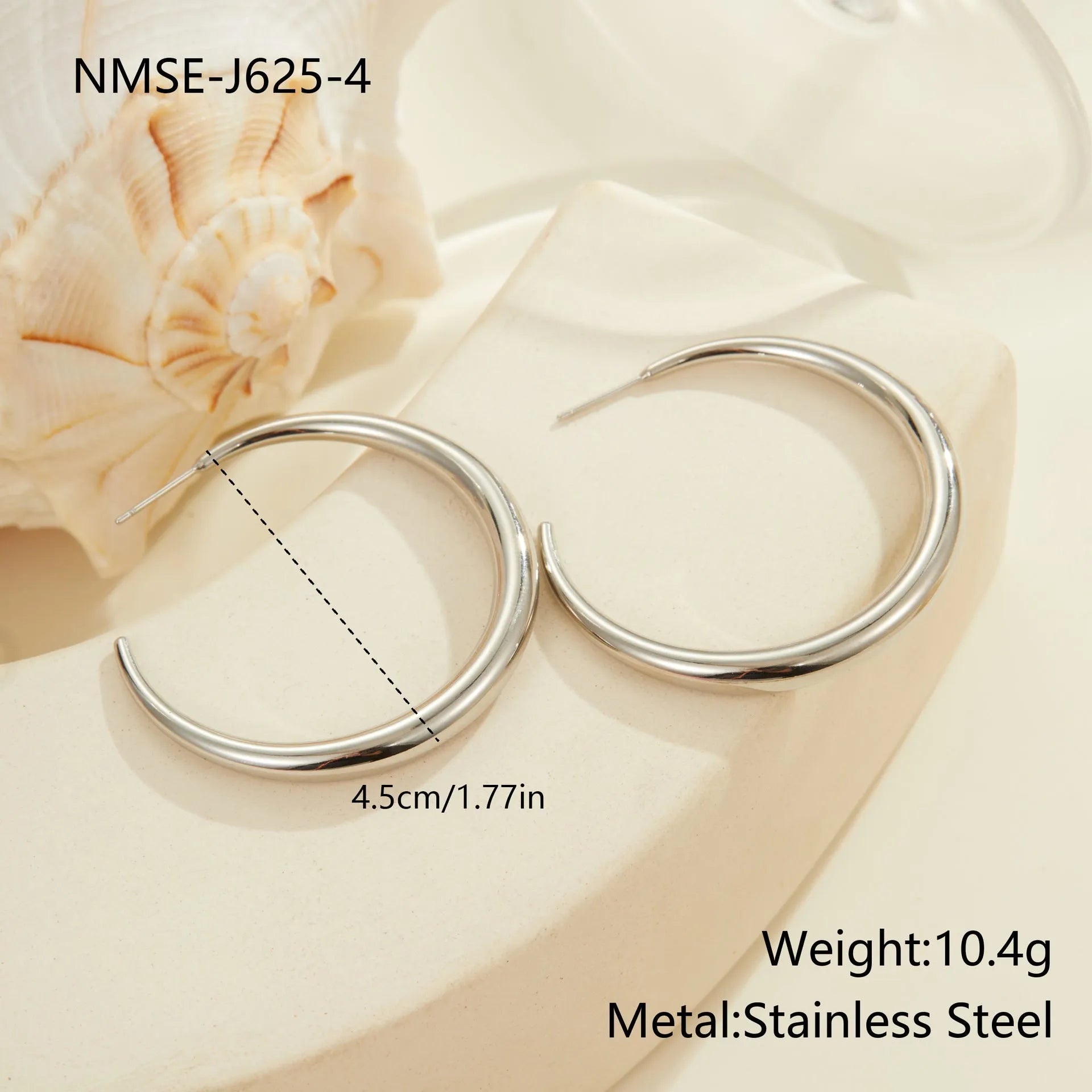 A pair of simple round titanium steel hoop earrings in a gold finish on a white background.