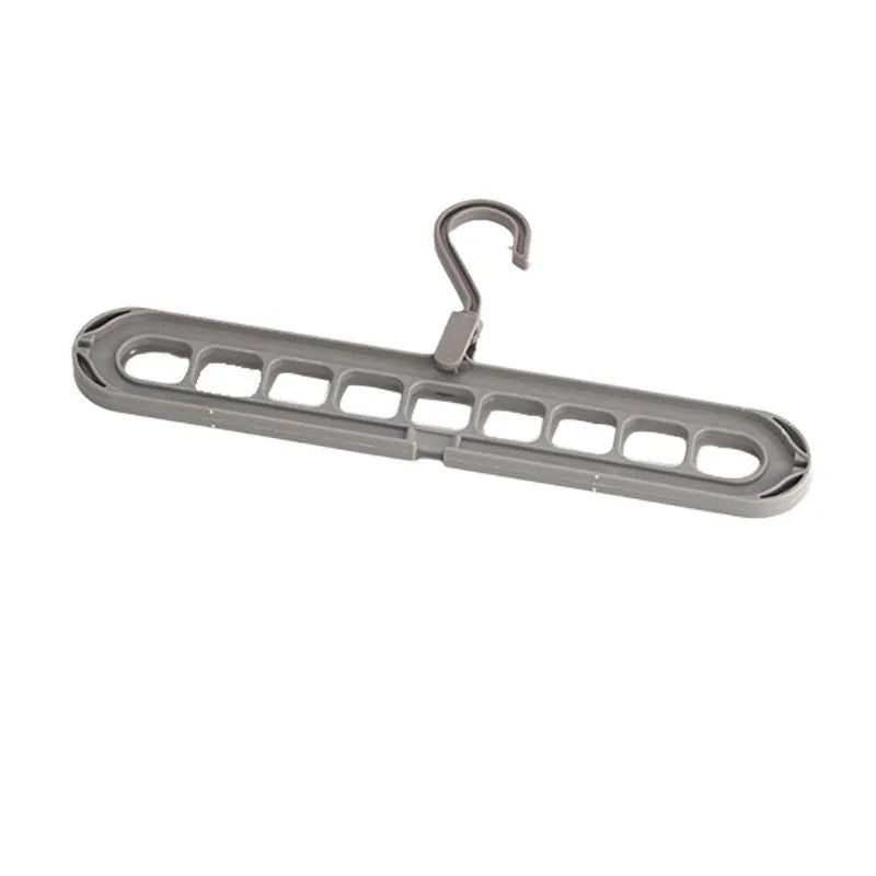 Green plastic nine-hole folding hanger for trousers shown in a dormitory wardrobe.