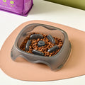 Blue plastic dog slow feeder bowl with anti-choking design on white background