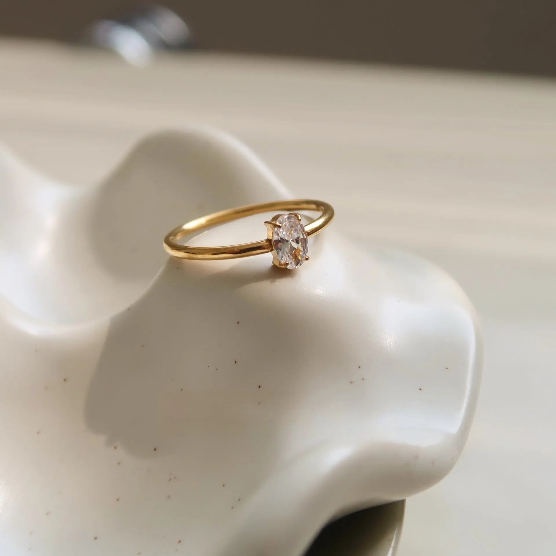 Golden heart-shaped stainless steel ring with love oval design on female hand
