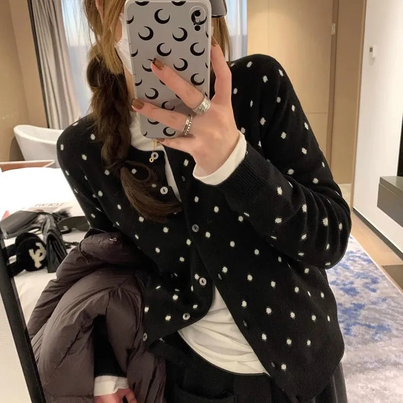Women's loose fit grey knitted cardigan with crocheted flower details on the front.