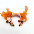Feather bell gall fruit cat toy in ginger colour with bells and feathers on green background