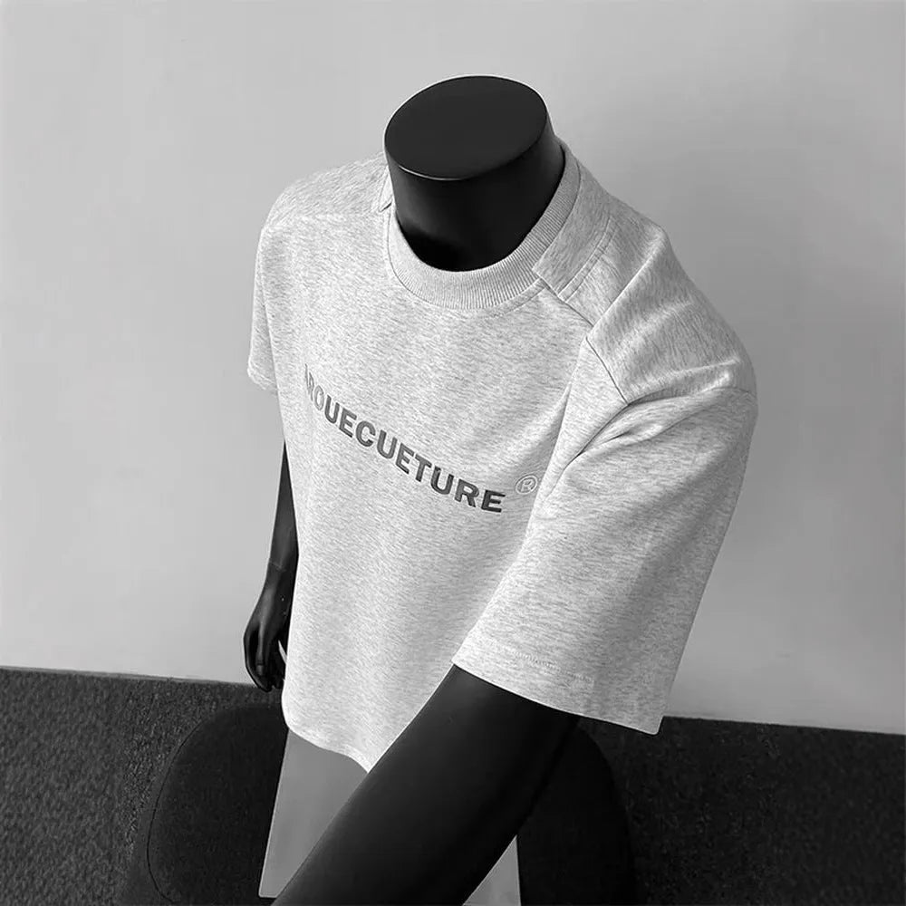 Men's loose fit cotton t-shirt with short sleeves and a printed letter design in light grey.