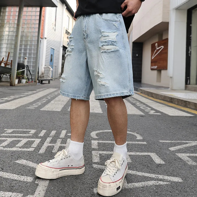 Light blue distressed denim shorts with ripped detailing and straight cut hip hop style