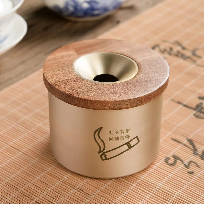 Brass ashtray with wooden lid showing central hole design for ash collection