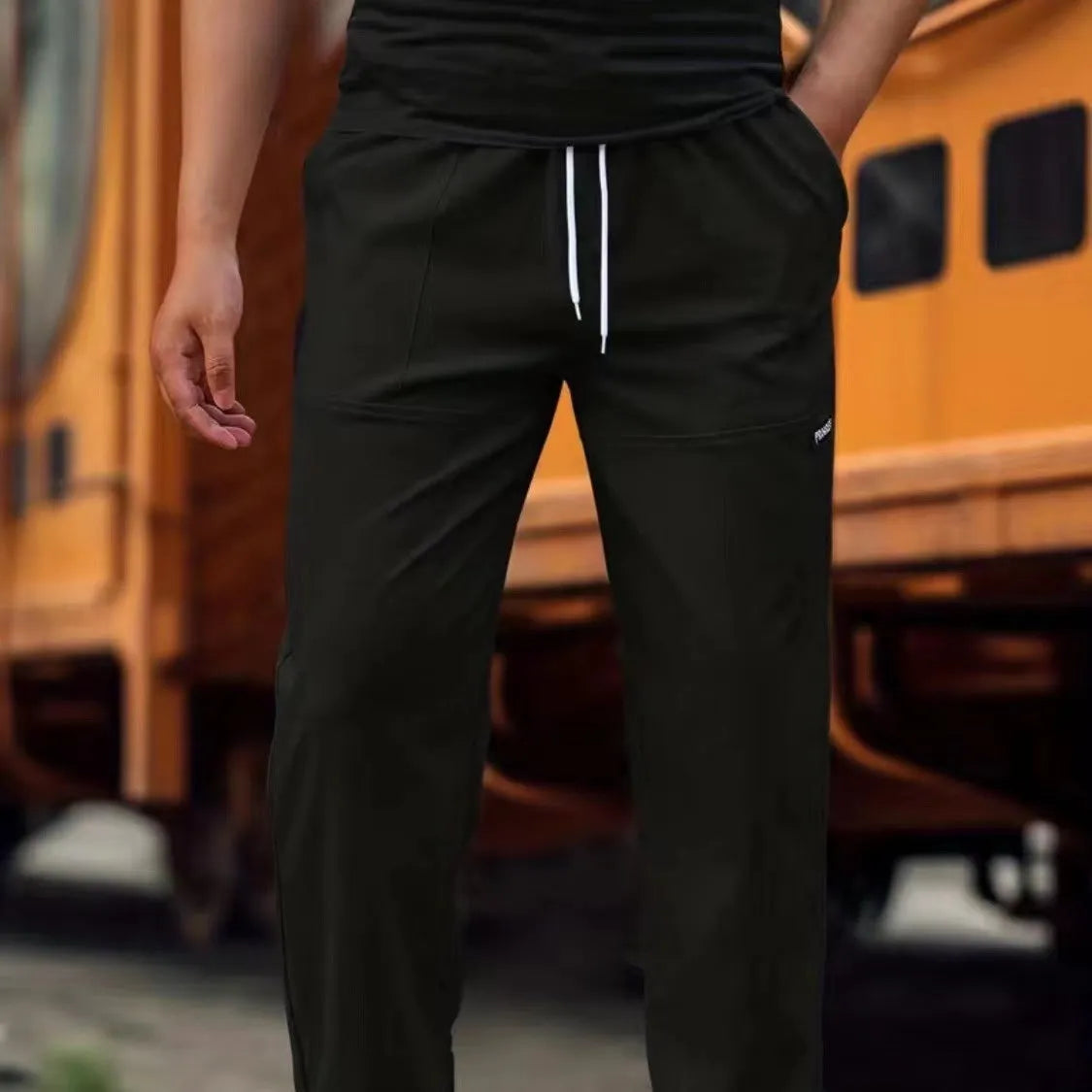 Men's polyester trousers for spring and autumn in light grey, shown flat.