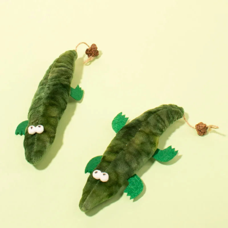 Green plush alligator catnip toy with peppermint scent on a white background.