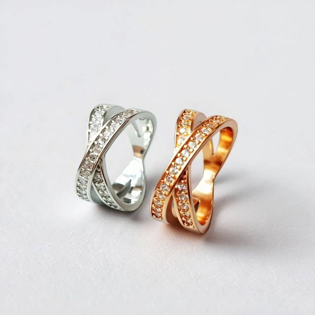 A silver or rose gold plated metal ring with a cross design and micro-inlaid zircon detail.