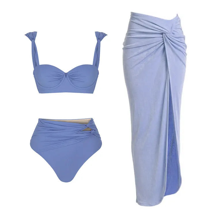Women's solid colour one-piece swimsuit with matching skirt and gold button detail.
