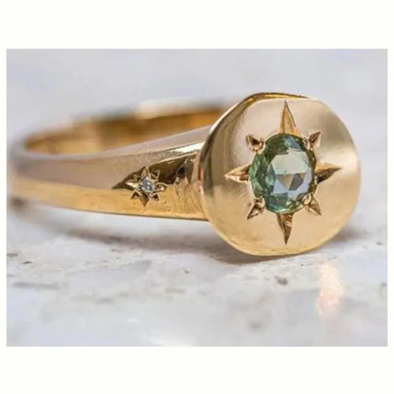 Gold-coloured adjustable ring with a star design and oval zircon stones.