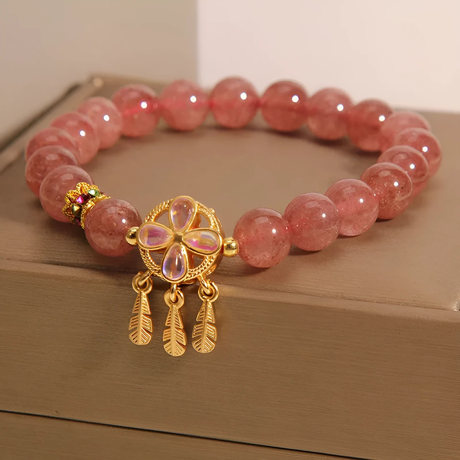 Women's strawberry quartz bracelet with four leaf dream catcher ball pendant