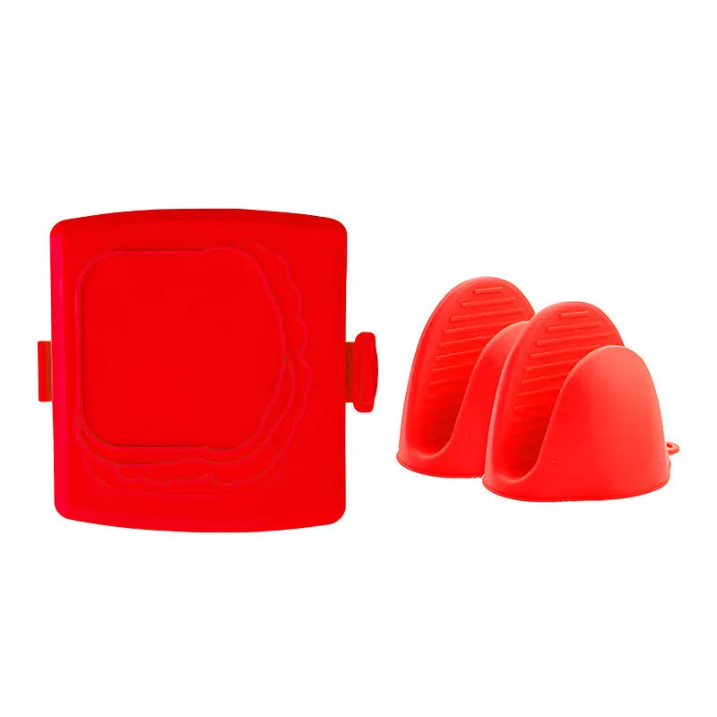 Red silicone baking tray with integrated handle and a pair of matching silicone oven gloves on a kitchen counter.
