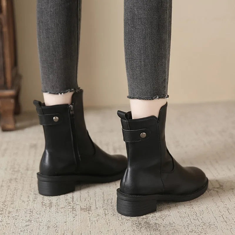 Black women's short ankle boots with a side zip, low heel, and round toe on a rubber sole.