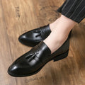 Men's black slip-on business casual shoe with a tassel detail on a low-top artificial PU upper.