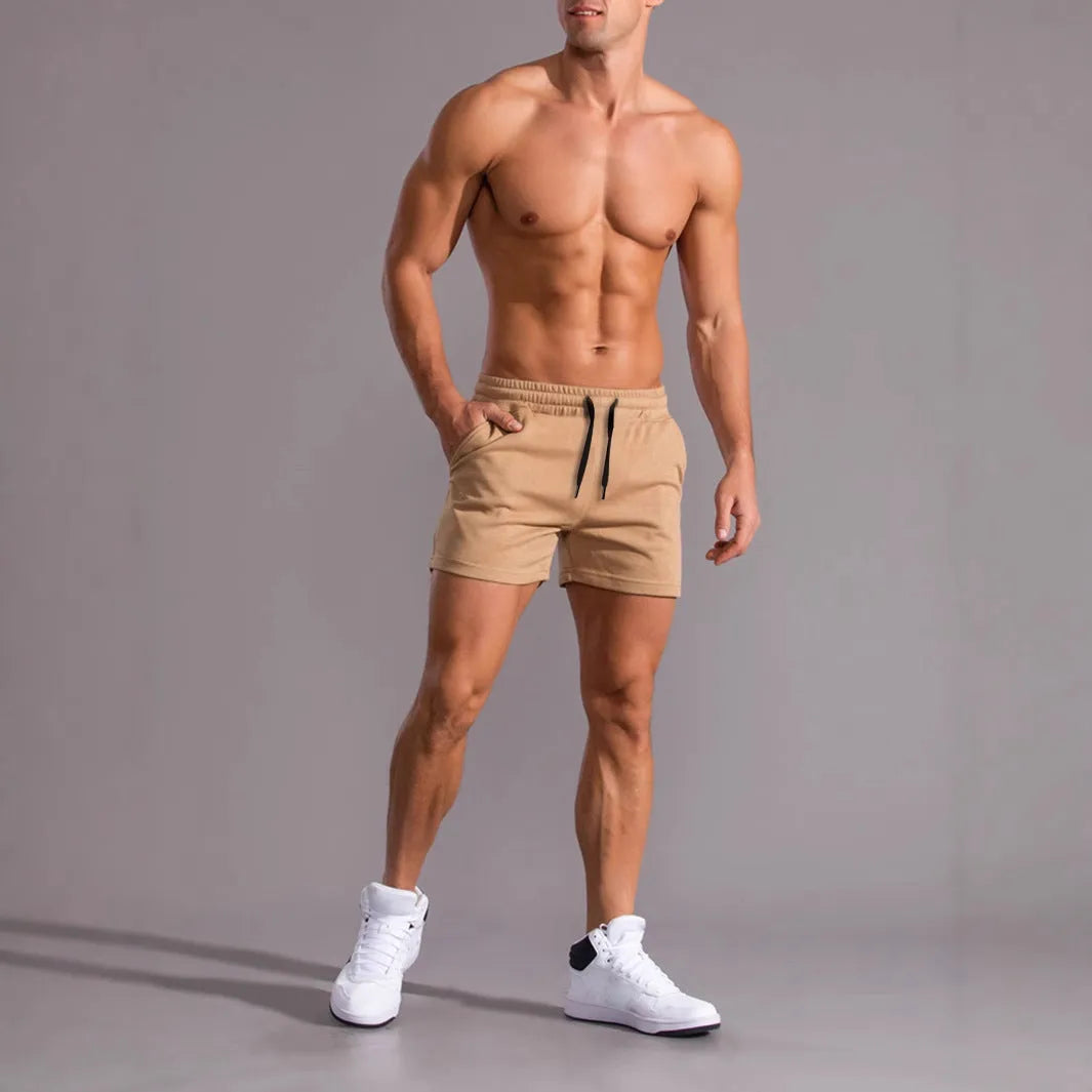 Three men's solid colour drawstring shorts laid flat showing loose fit and adjustable waistband.