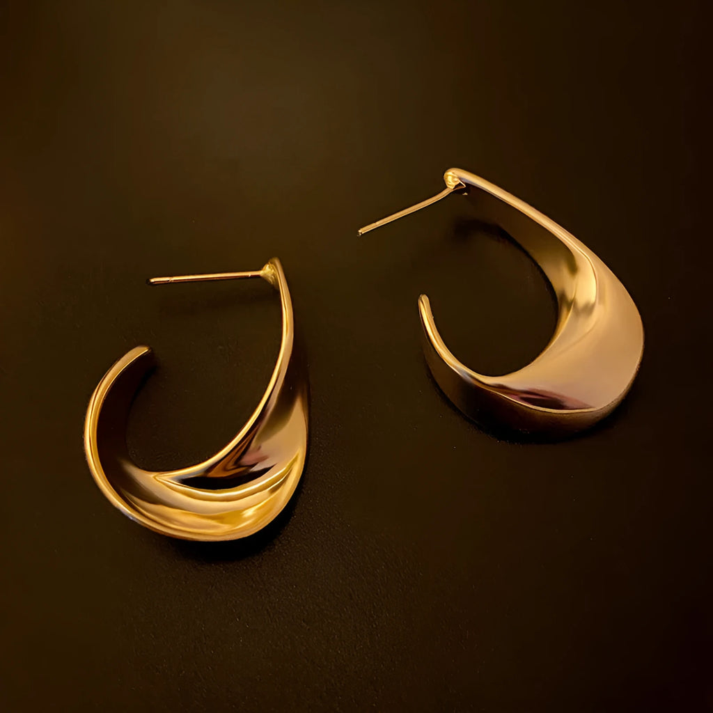 Metal geometric twisted earrings with round elements in gold or silver electroplated finish