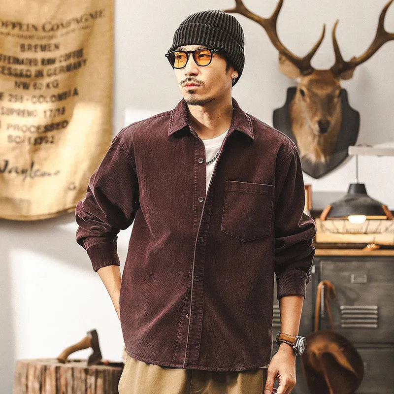 Man wearing a red loose-fit corduroy shirt jacket with long sleeves.