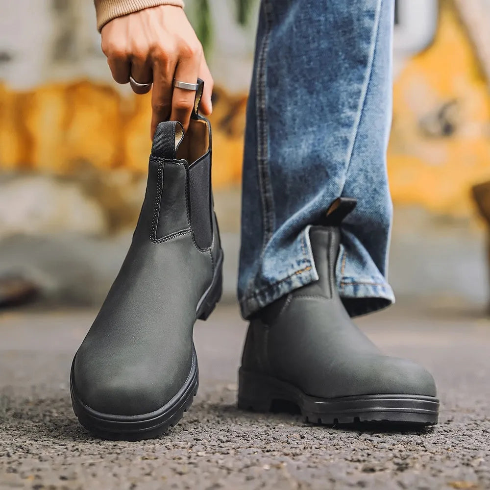 Vintage brown unisex Chelsea boot with frosted PU upper and round toe on a wooden surface.