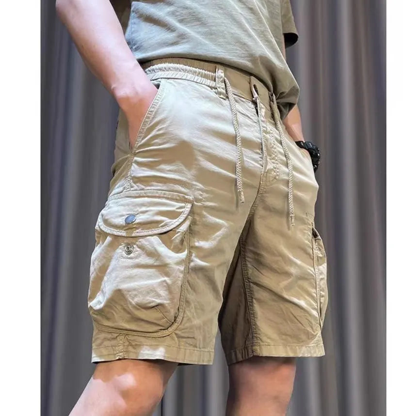A model wearing loose straight-leg multi-pocket overalls in a khaki colour.