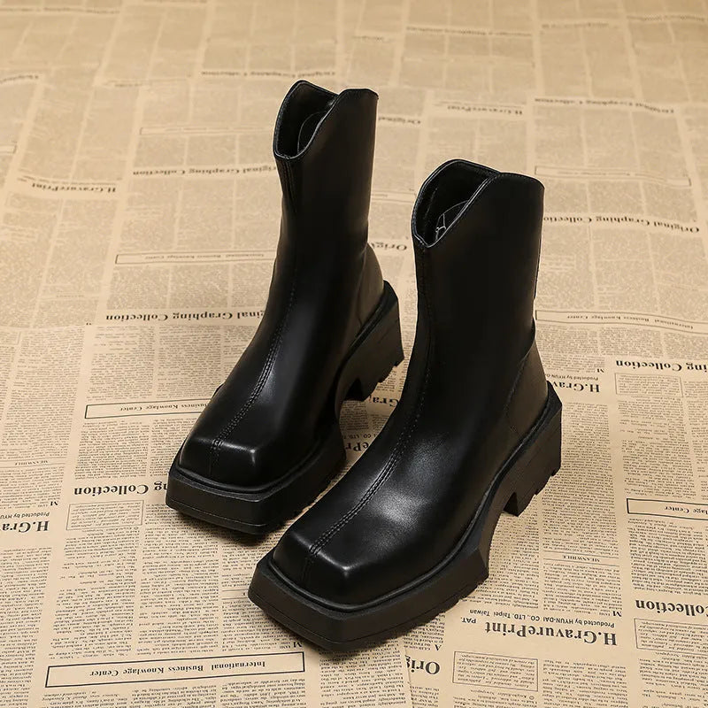 Women's black platform Martin ankle boots with a square toe, chunky sole, and back zipper.