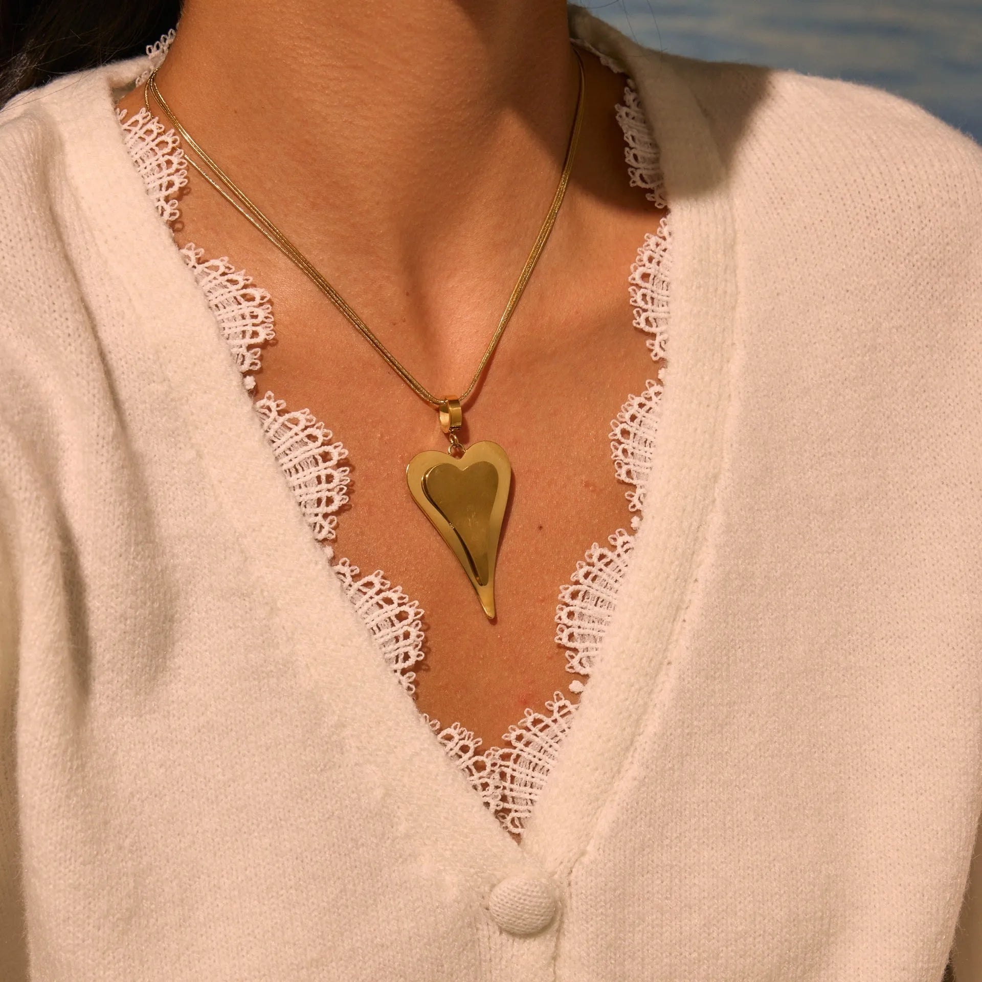 Stainless steel necklace with geometric double heart design formed from snake bones chain elements