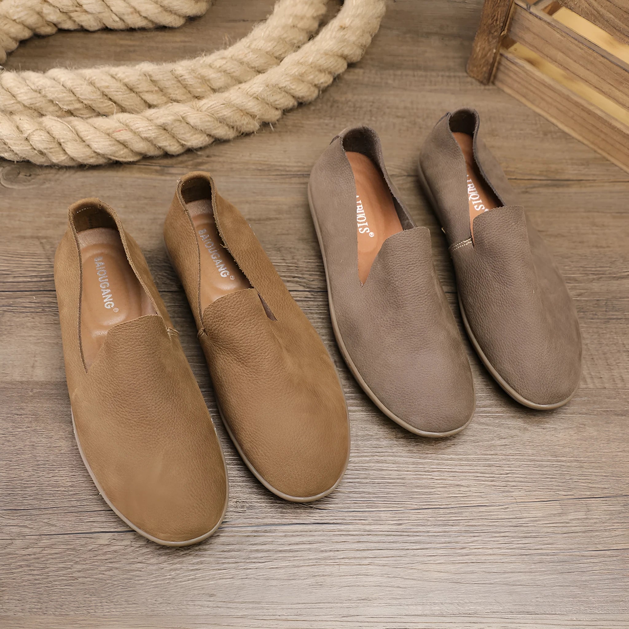 Handmade grey men's low-top leather shoes with a flat wedge rubber sole on a plain background.