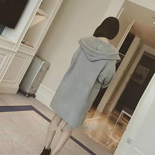 Plus size woman modelling a loose grey cotton coat with lace detailing and long sleeves.