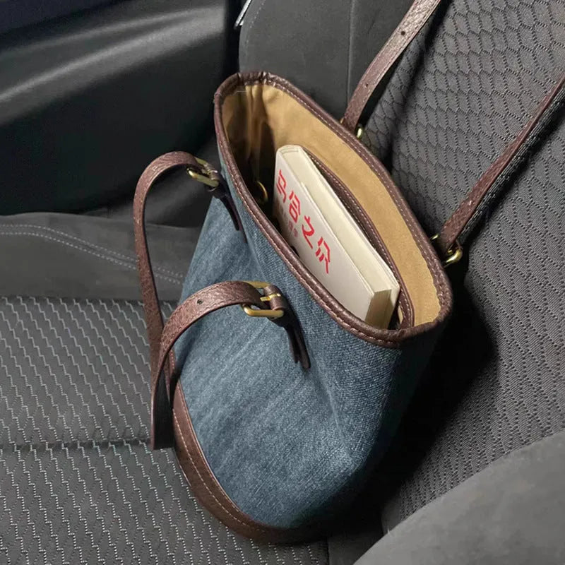 Blue denim patchwork one-shoulder bucket handbag with a large opening.