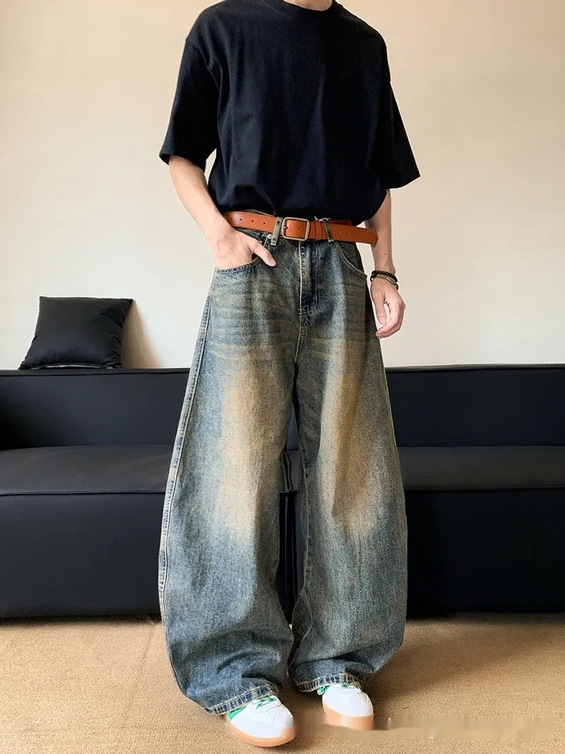 Men's retro blue distressed denim pants with a slim wide-leg fit and a zipper fly.