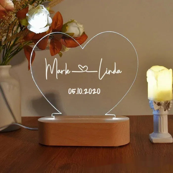 Custom engraved acrylic night light with LED base, showing personalised names and date.