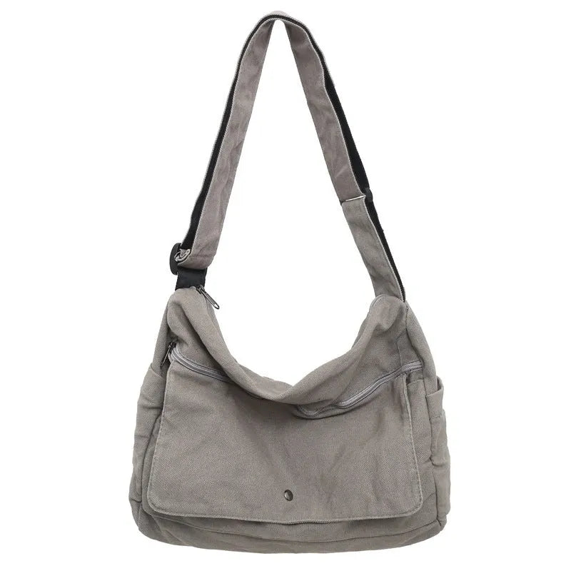 Washed canvas crossbody bag for women in black with single shoulder strap and clamshell shape