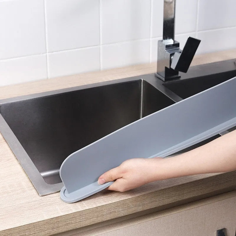 Thick grey blue silicone sink water blocking plate measuring 52mm by 85mm.