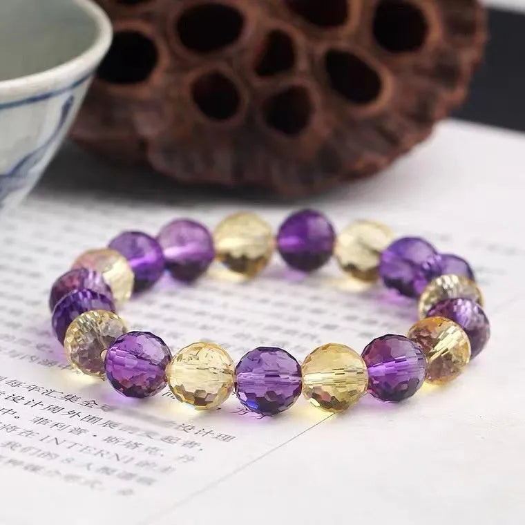 Handcrafted 128-facet crystal ametrine bracelet with detailed beads on a wrist.