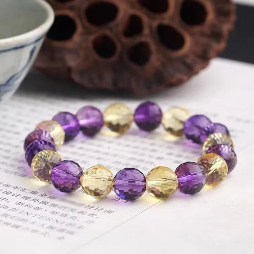 Handcrafted 128-facet crystal ametrine bracelet with detailed beads on a wrist.