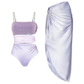 Purple women's one-piece swimsuit with hollow design and matching wrap skirt.