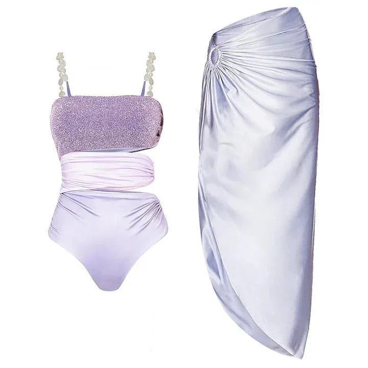 Purple women's one-piece swimsuit with hollow design and matching wrap skirt.