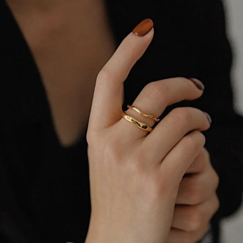 Women's stainless steel ring with wavy geometric design, 18K gold plated, in golden colour, on finger