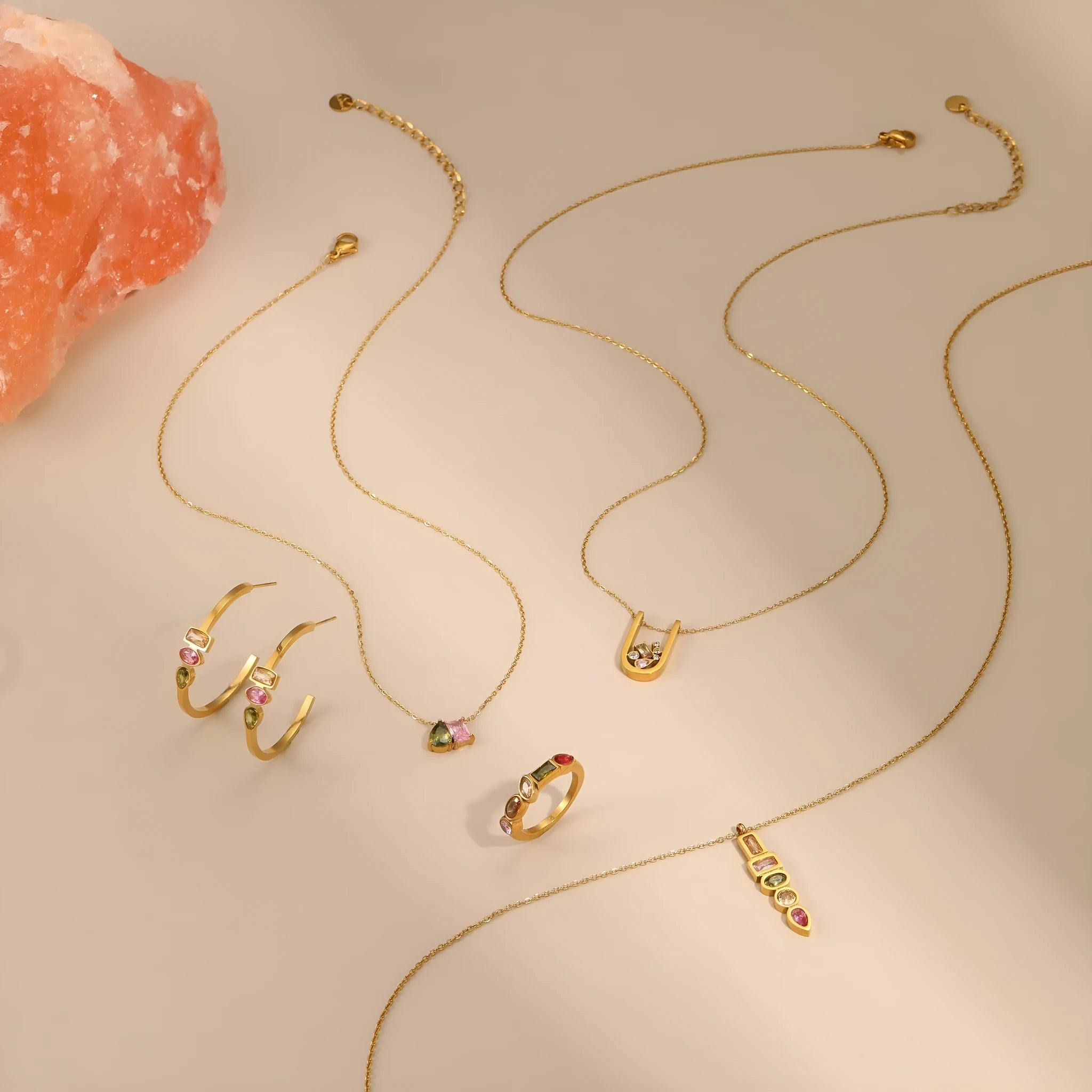 Geometric colour zircon gold plated jewellery set showing necklace, earrings and ring on black background