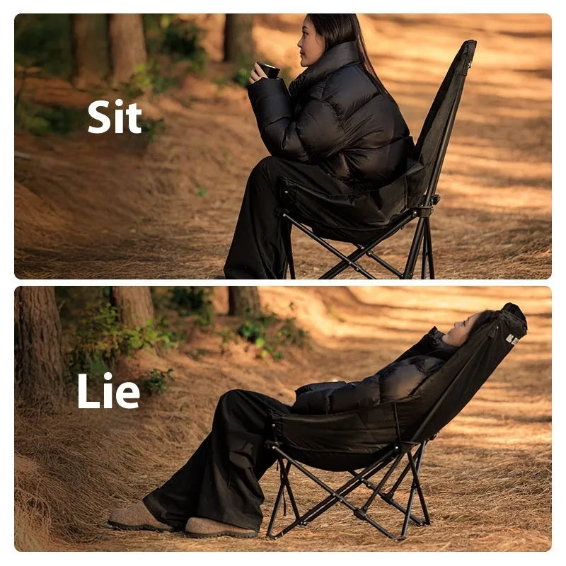 Night Black portable folding moon chair in use outdoors, showing its reclined design and carry handle.