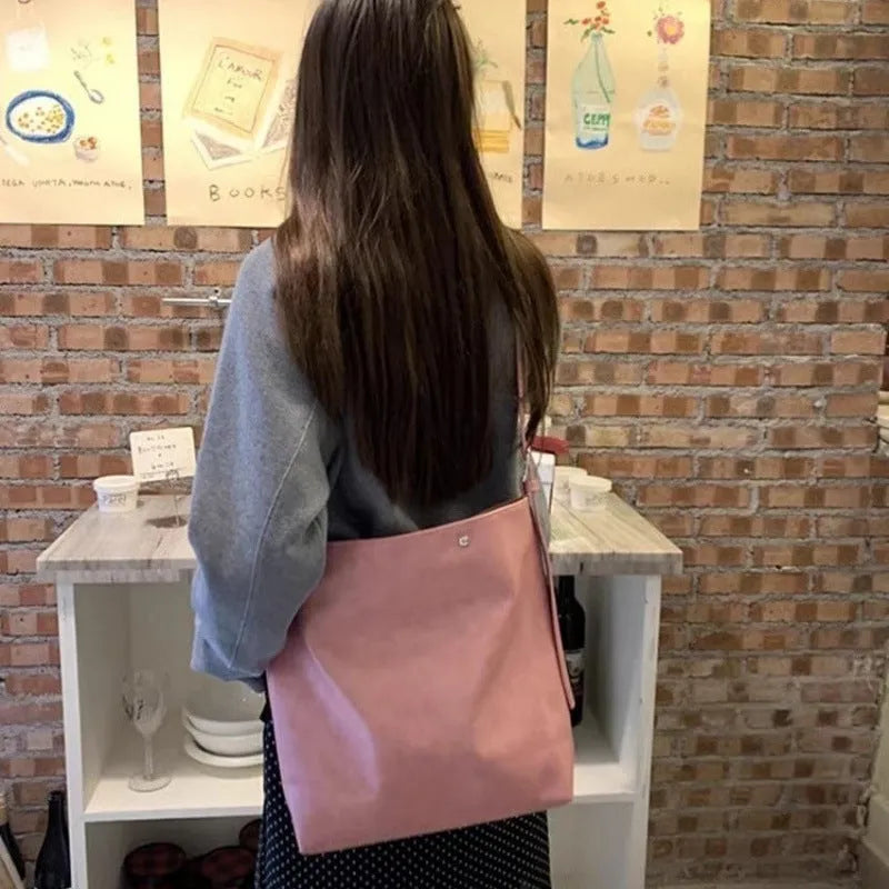 Pink corduroy one-shoulder commuter bag with a single strap and PU lining.