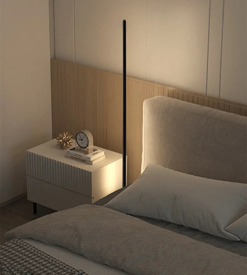 Modern simple vertical aluminium alloy floor lamp in silver, shown beside a sofa.