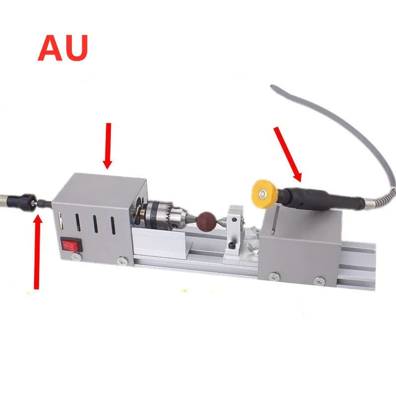Silver metal mini woodworking lathe on a bench with carving knives and accessories.