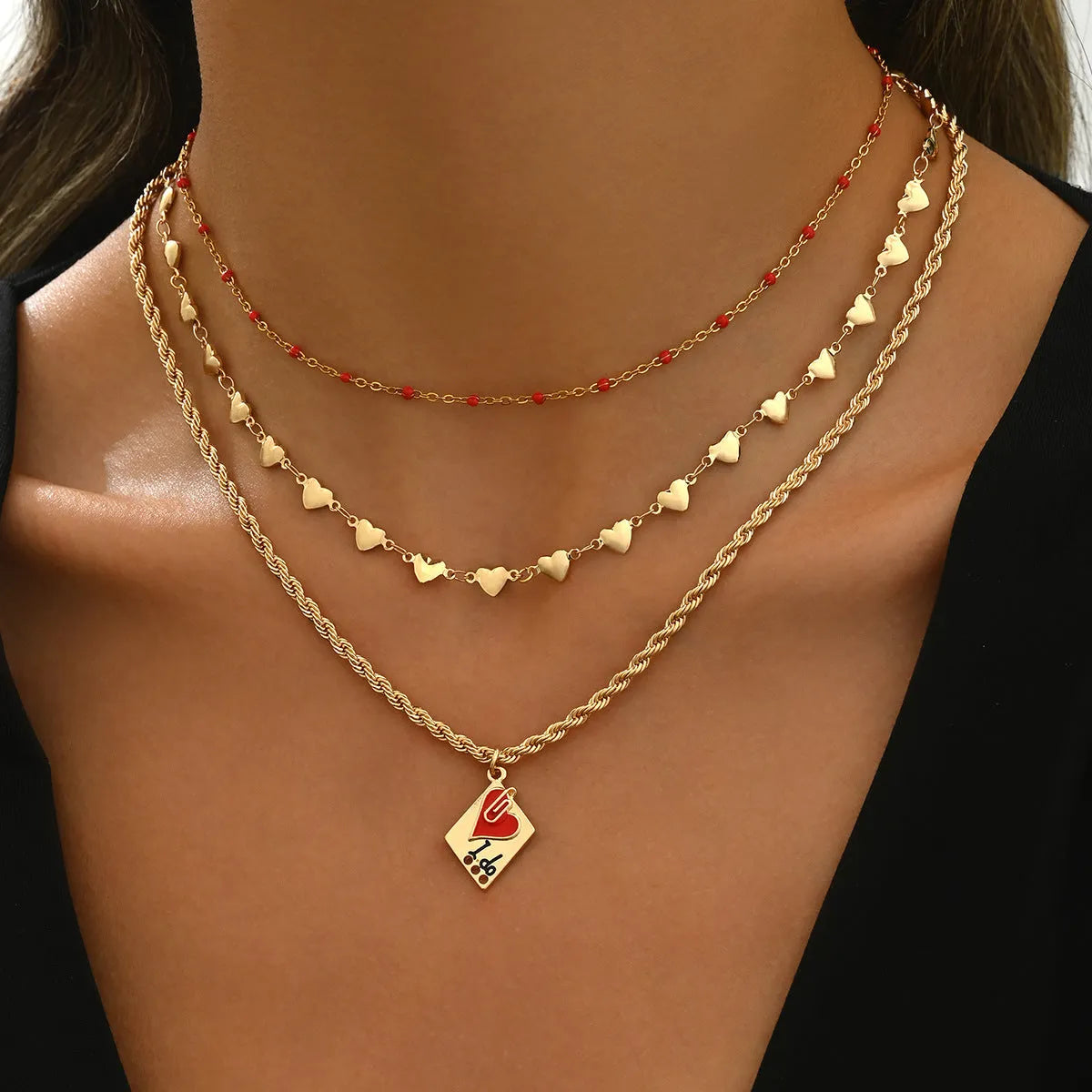 Geometric three-layer heart pendant necklace on a model, showing adjustable clavicle chain length.